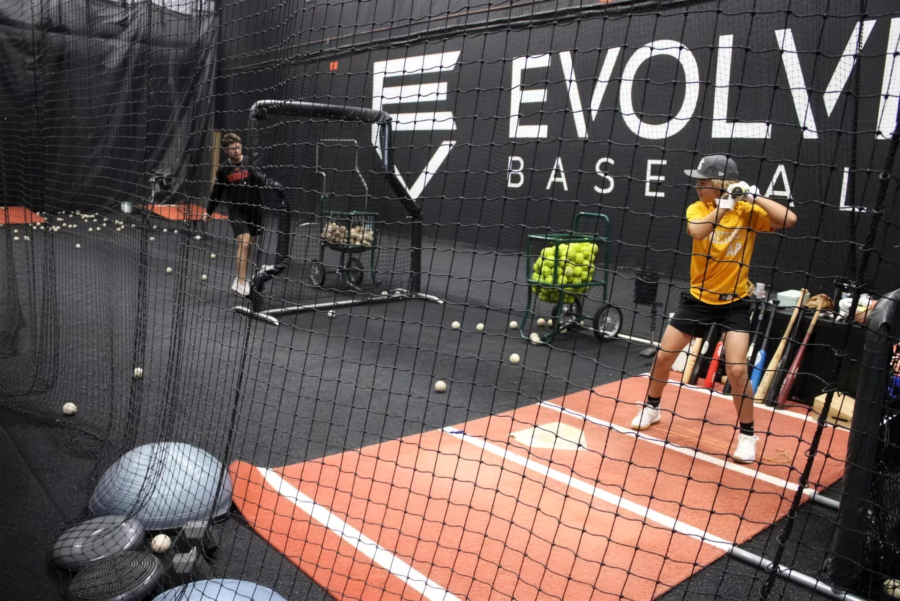 Player taking swings in the Evolve hitting cage