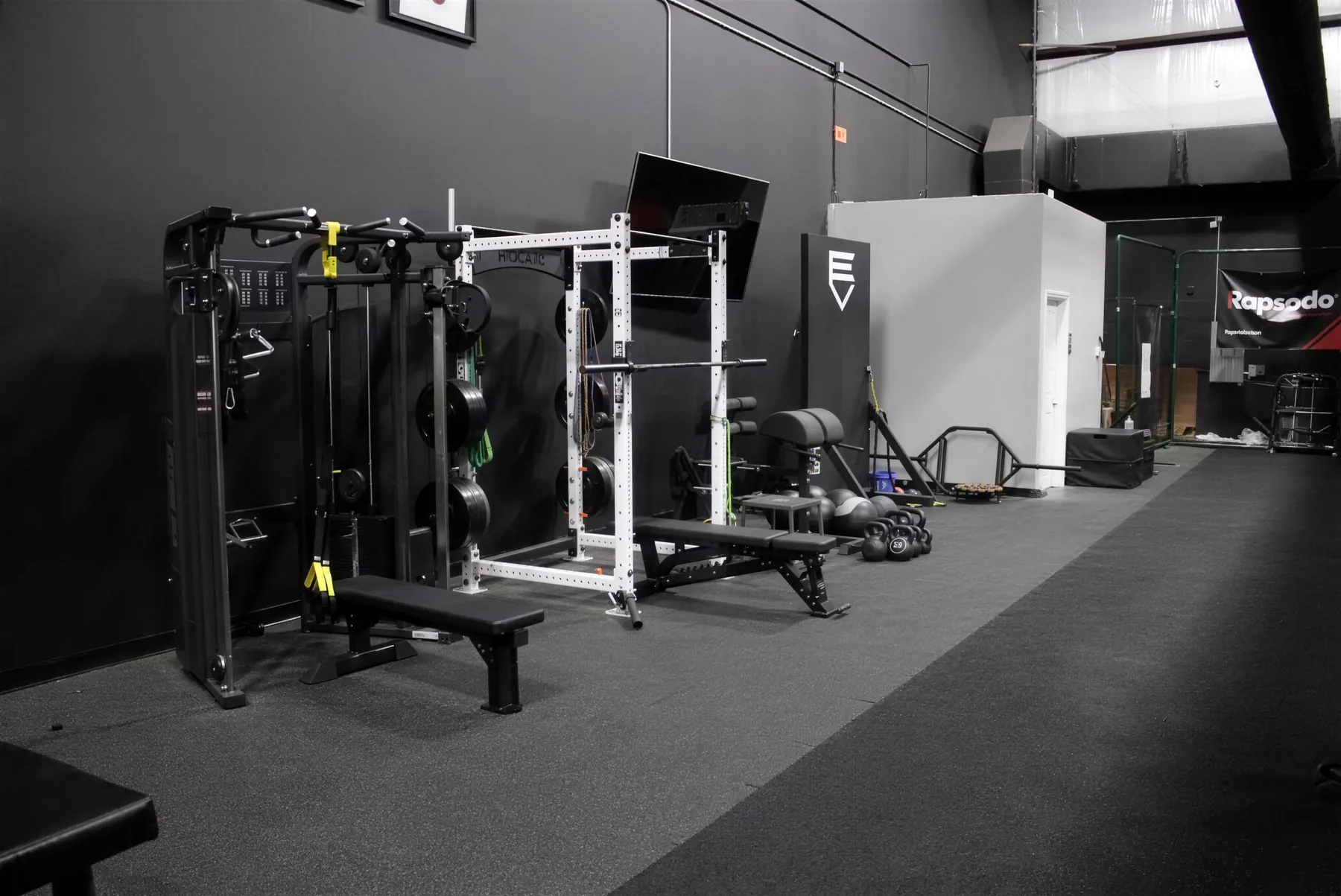 Strength and conditioning area at Evolve Baseball with racks and turf